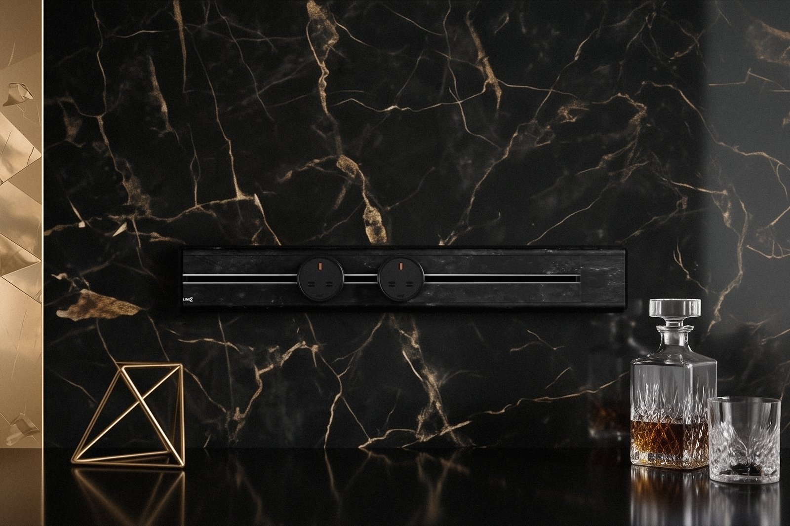 Premium Line8 Model SL electrical power track showcasing a luxurious Spanish Black Marble finish. Mounted against a dramatic, matching black marble wall with striking gold veining, the high-end architectural fitting features a sleek black center channel and includes two circular black power adaptors. The track seamlessly integrates above a highly reflective black countertop, elegantly styled with a gold geometric wire sculpture and a classic crystal decanter set.