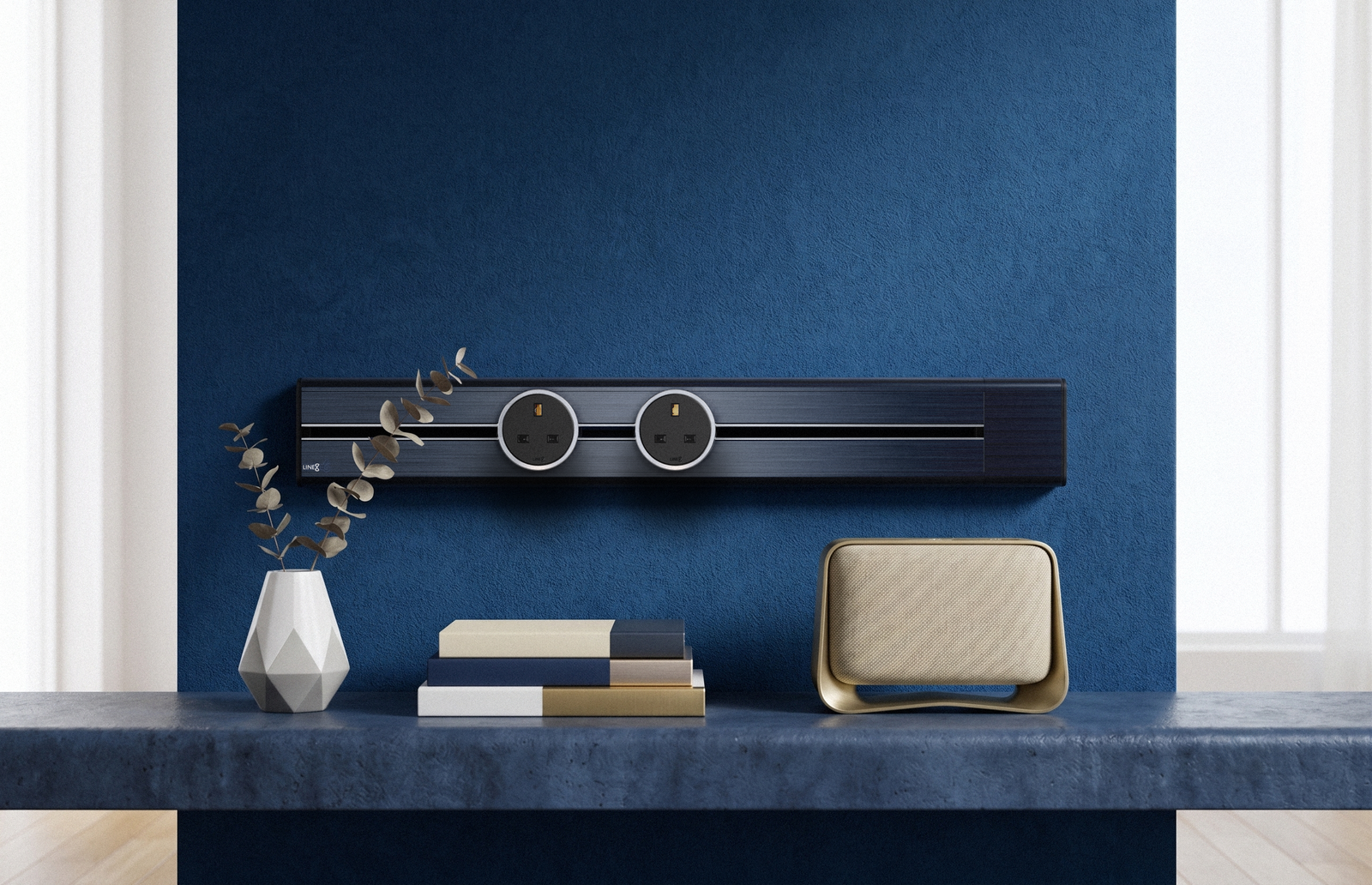 Premium Line8 Model SL electrical power track showcasing a striking Galaxy Blue finish. Mounted against a richly textured navy blue accent wall, the high-end architectural fitting features a contrasting black center channel and two circular black power adaptors. The track is elegantly positioned above a matching blue countertop, thoughtfully styled with a geometric white vase, stacked books, and a modern gold-accented speaker.